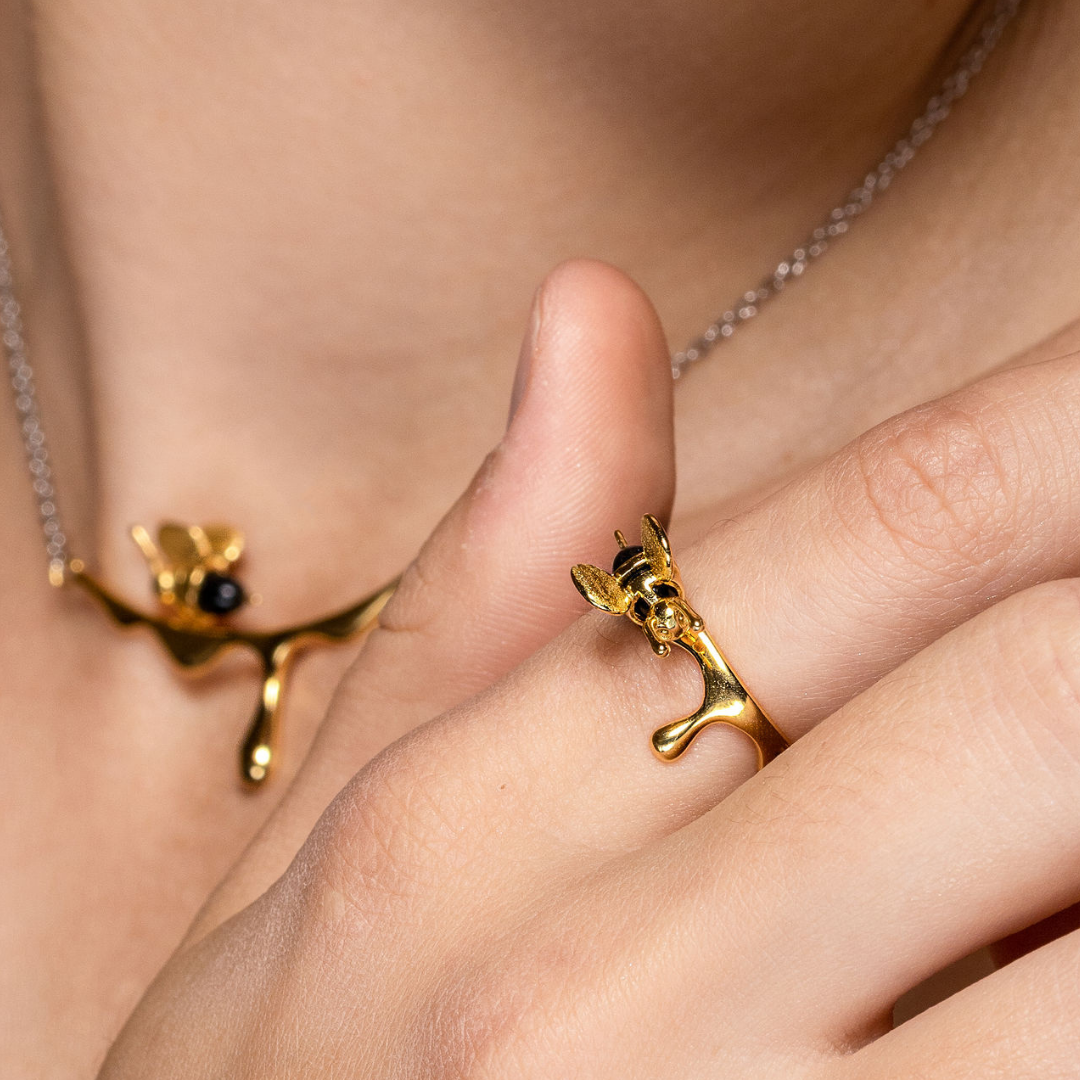 Elegant gold ring featuring bee detail and modern wavy band


