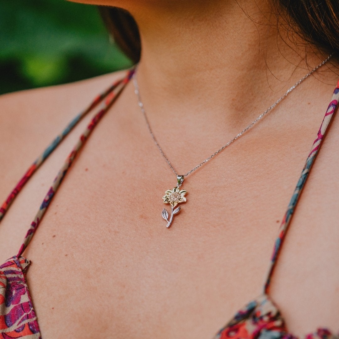 Delicate sunflower pendant necklace with gold and silver tones, symbolizing happiness and positivity – perfect gift for sunflower lovers.

