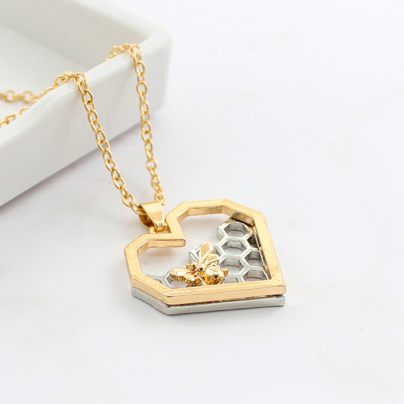 Heart-shaped honeycomb pendant necklace with gold bee design

