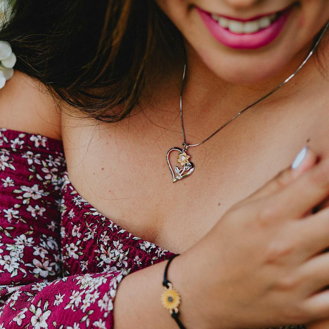 Romantic sunflower jewelry pendant featuring gold petals and silver heart frame

