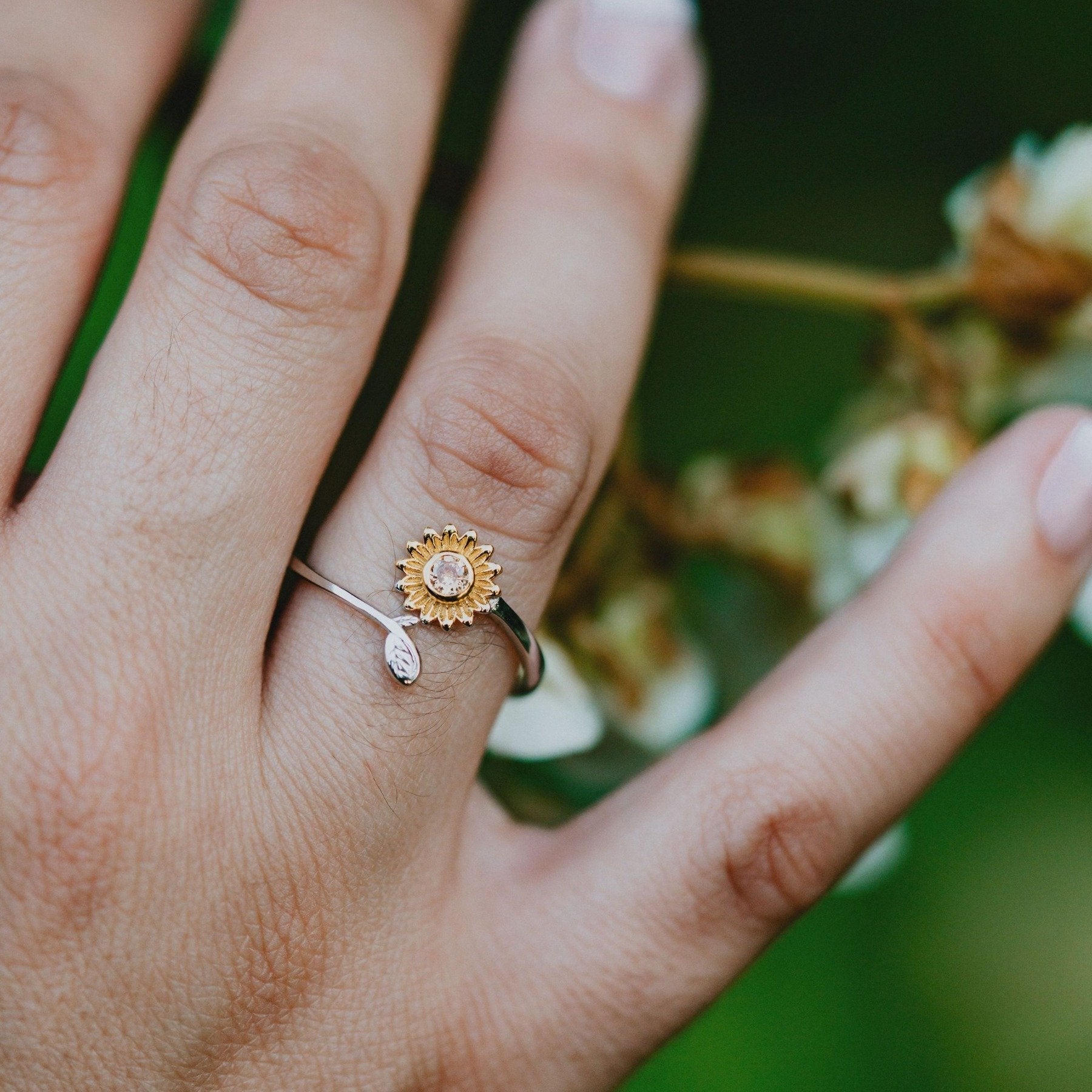 Minimalist sunflower design ring with leaf detail on band

